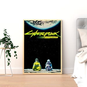 Puede incluir: Un p&oacute;ster enmarcado con el logotipo de Cyberpunk: Edgerunners en verde ne&oacute;n y amarillo. La obra de arte representa dos figuras sentadas en una superficie lunar, con un planeta y un fondo estrellado. El p&oacute;ster est&aacute; en un marco de madera.