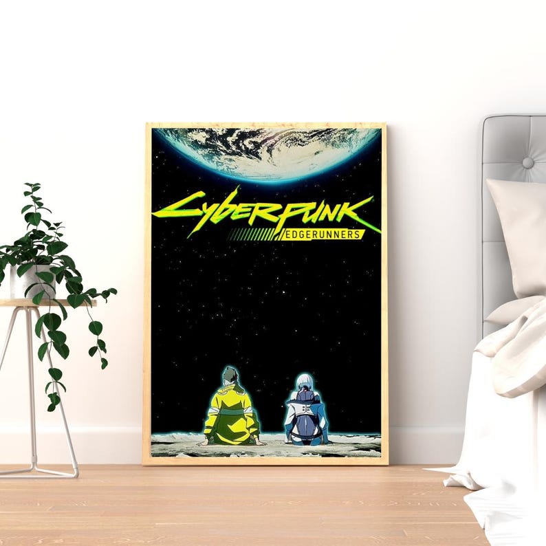 Puede incluir: Un p&oacute;ster enmarcado con el logotipo de Cyberpunk: Edgerunners en verde ne&oacute;n y amarillo. La obra de arte representa dos figuras sentadas en una superficie lunar, con un planeta y un fondo estrellado. El p&oacute;ster est&aacute; en un marco de madera.