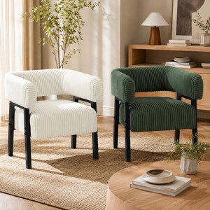 Puede incluir: Dos sillones modernos con estructura de metal negro. Uno est&aacute; tapizado en tela de pana color crema, y el otro en pana verde oscuro. Las sillas tienen respaldos y reposabrazos curvos, y est&aacute;n sobre una alfombra de tonos neutros.
