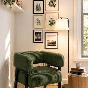 Puede incluir: Ambiente de sal&oacute;n con un sill&oacute;n de pana verde, marcos negros y una galer&iacute;a de estampados bot&aacute;nicos enmarcados. Una mesa auxiliar de madera, una l&aacute;mpara de pie y una estanter&iacute;a con una planta y una vela completan el espacio.