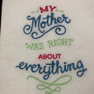 May include: White kitchen towel with embroidered text in red, blue, and green. The text reads "MY Mother WAS RIGHT ABOUT everything" in a decorative script font. The towel has a textured surface.