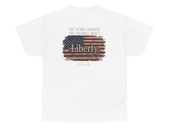 May include: A white short-sleeved t-shirt featuring a distressed American flag graphic on the back. The text reads: THE STARS CHANGED. THE PROMISE DIDN'T. Liberty. 1776 - 2026. The design is centred with a weathered, vintage-style flag print.