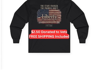 Puede incluir: Una camiseta negra de manga larga con un gráfico de una bandera estadounidense desgastada. Sobre la bandera está el texto THE STARS CHANGED. THE PROMISE DIDN'T. En el centro de la bandera está la palabra Liberty. Bajo la bandera está 1776-2026.