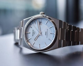 Reloj automático Tissot PRX Powermatic 80 con esfera azul hielo y brazalete de acero inoxidable.