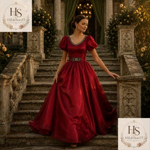 May include: A formal, floor-length red gown with short, puffed sleeves and a jeweled neckline and belt. The dress is made of a shiny fabric and is worn on a stone staircase. The image includes the text "HS LifeStoreTT".