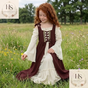 May include: A floor-length dress featuring a cream-coloured underlayer with long flared sleeves and an off-the-shoulder neckline, paired with a dark brown sleeveless overdress that has a lace-up bodice with decorative gold-toned trim.