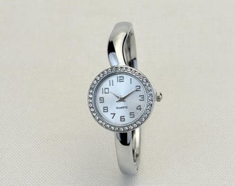 Reloj de pulsera de cuarzo para mujer con caja redonda plateada, bisel de cristal y brazalete tipo brazalete.
