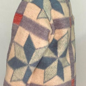 May include: A multi-colored jacket with a geometric star pattern. The jacket features a mix of colors including beige, blue, purple, and red. The jacket has a high collar and a button closure. The jacket is made of a soft, textured material.