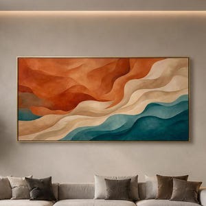 Puede incluir: Una gran pieza de arte mural rectangular con ondas abstractas fluidas en tonos naranja quemado, crema y verde azulado profundo. La obra de arte está enmarcada con un borde dorado fino y cuelga sobre un largo sofá seccional gris claro.