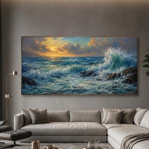 Puede incluir: Una gran pieza de arte mural rectangular que representa una escena oceánica turbulenta con olas rompiendo contra rocas oscuras bajo un cielo de atardecer dorado con nubes, exhibida sobre un sofá seccional gris claro en una sala de estar.
