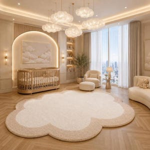 May include: A large, cloud-shaped area rug in cream and beige tones placed on a light wood herringbone floor. The room features a rounded wooden crib, a curved sofa, a plush armchair with an ottoman, and cloud-shaped pendant lights.