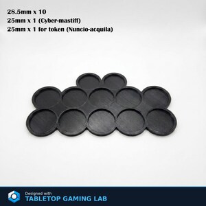 Puede incluir: Base de juego de mesa de pl&aacute;stico negro con 12 ranuras circulares. La base est&aacute; dise&ntilde;ada para sujetar miniaturas y fichas. El texto de la imagen dice: 28,5 mm x 10, 25 mm x 1 (Cyber-mastiff), 25 mm x 1 para ficha (Nuncio-acquila). Dise&ntilde;ado con TABLETOP GAMING LAB.