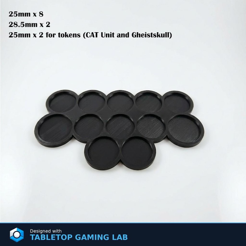 Puede incluir: Base de juego de mesa de pl&aacute;stico negro con 12 ranuras circulares. El texto de la imagen dice: 25 mm x 8, 28,5 mm x 2, 25 mm x 2 para fichas (CAT Unit y Gheistskull). Dise&ntilde;ado con TABLETOP GAMING LAB.