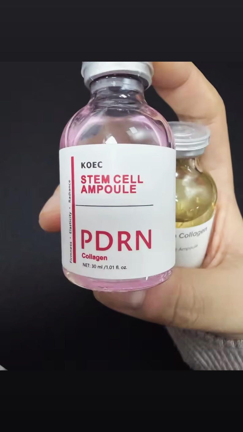 May include: A pink-tinted glass vial labeled "KOEC STEM CELL AMPOULE PDRN Collagen" with a net volume of 30 ml / 1.01 fl. oz. The vial is held next to a smaller vial with a white label that reads "Collagen Ampoule".