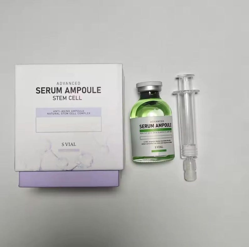 May include: A white box and a green serum bottle with a syringe. The box reads "ADVANCED SERUM AMPOULE STEM CELL" and "ANTI-AGING AMPOULE NATURAL STEM CELL COMPLEX". The bottle also reads "ADVANCED SERUM AMPOULE".