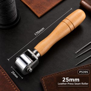 May include: A leather press seam roller with a light brown wooden handle and a polished silver metal wheel. The tool features a total length of 170mm and a roller width of 25mm. The text P5395 and 25mm Leather Press Seam Roller are visible.