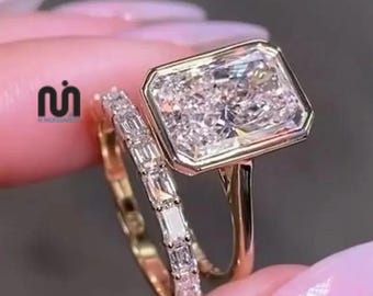 Set di anelli di fidanzamento solitario con moissanite taglio radiante da 4 carati incastonata a castone per donna, con fede nuziale abbinata in oro 14 carati e smeraldo.