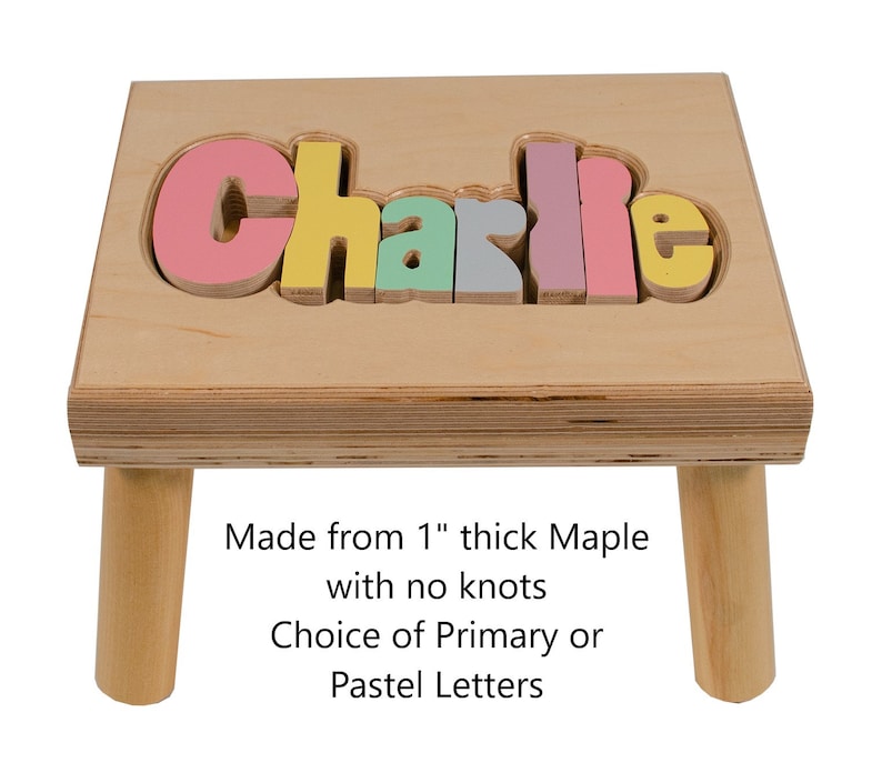 Step stool with four legs that has the name Charlie puzzled into the top where each letter is a puzzle piece.  Letters are painted in bright pastel colors in a rainbow pattern starting with pink. Maximum of 8 letters 1 name.