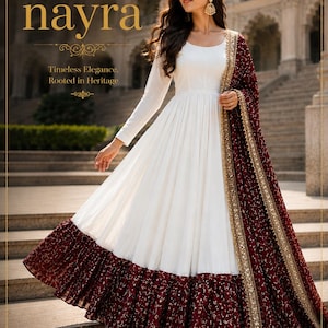 Könnte beinhalten: Ein weißes Langarmkleid mit ausgestelltem Rock, mit einem bordeauxfarbenen Saum und einem passenden Schal. Der Schal und der Saum sind mit goldenen Akzenten verziert. Das Kleid trägt den Text "label nayra" und "Timeless Elegance, Rooted in Heritage".