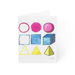 Puede incluir: Una tarjeta de felicitación con una ilustración en acuarela de nueve formas geométricas dispuestas en una cuadrícula de tres por tres. La fila superior muestra un contorno de círculo rosa, un círculo rosa sólido y una esfera rosa sombreada. La fila central muestra un contorno de cuadrado azul, un cuadrado azul sólido y un cubo azul. La fila inferior contiene un contorno de triángulo amarillo, un triángulo amarillo sólido y una pirámide amarilla. El nombre Lindsay está escrito en cursiva en la esquina inferior derecha.