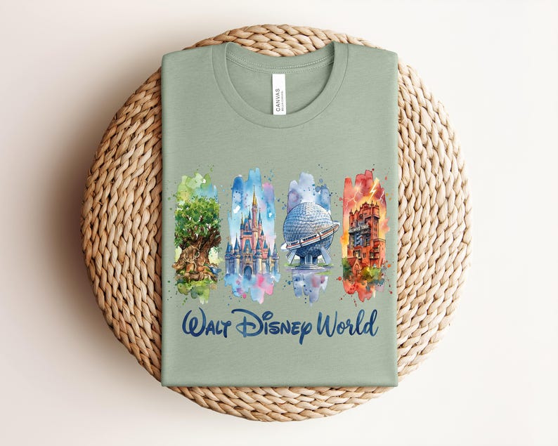 May include: Sage green t-shirt featuring watercolor illustrations of iconic Walt Disney World landmarks: the Tree of Life, Cinderella Castle, Spaceship Earth, and the Tower of Terror. The words "Walt Disney World" are written in a script font below the illustrations.