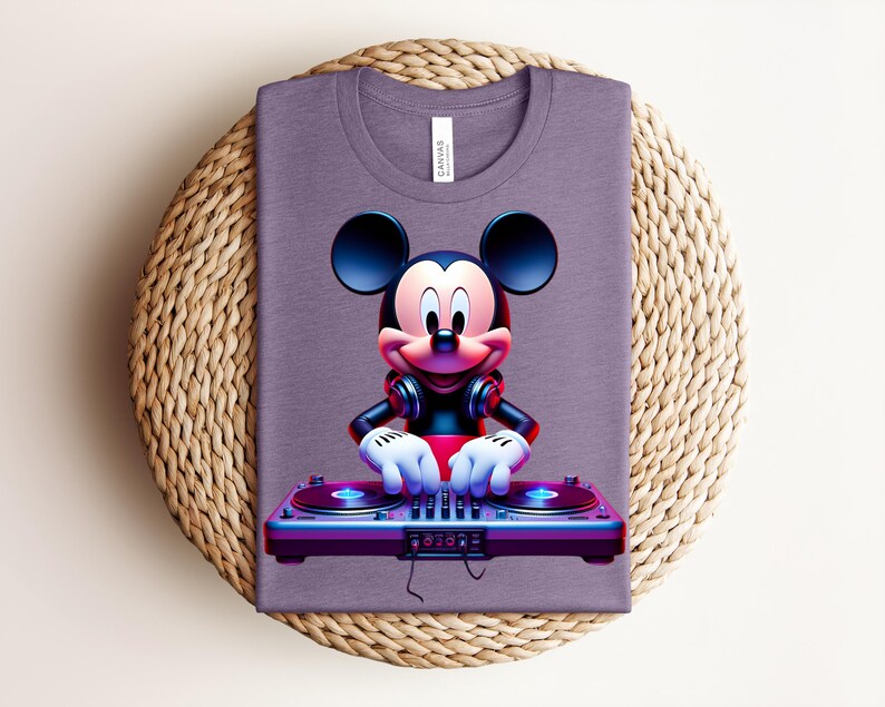 May include: A purple t-shirt featuring a vibrant graphic of Mickey Mouse as a DJ. Mickey is wearing headphones and has his hands on a turntable. The shirt is folded and placed on a woven, circular mat.