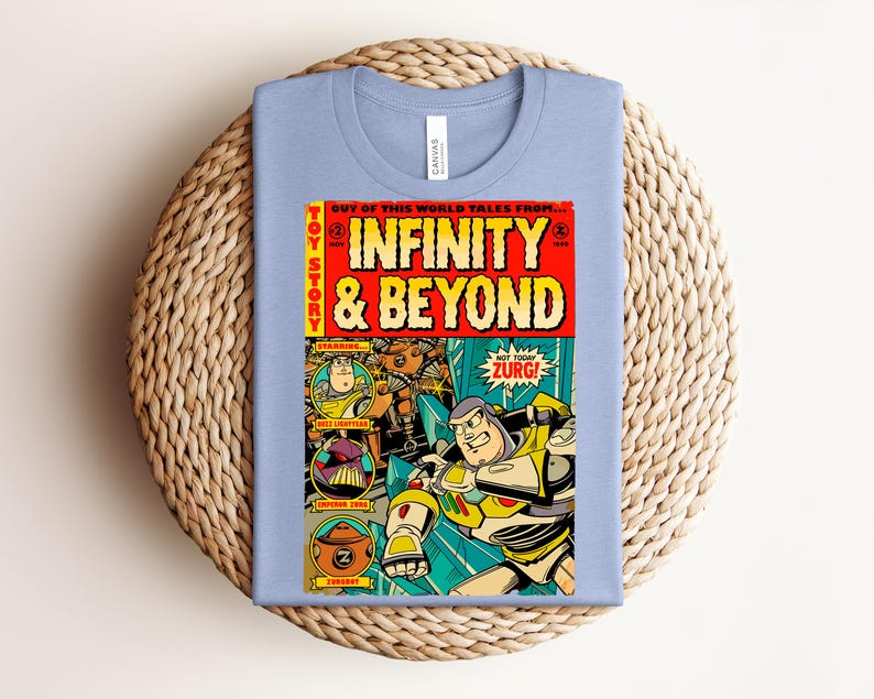 Puede incluir: Una camiseta azul claro con un gr&aacute;fico de portada de c&oacute;mic titulado Infinity & Beyond. El dise&ntilde;o incluye ilustraciones de Buzz Lightyear, el Emperador Zurg y Zurgbot, con elementos de texto en amarillo y rojo y un estilo de c&oacute;mic vintage.