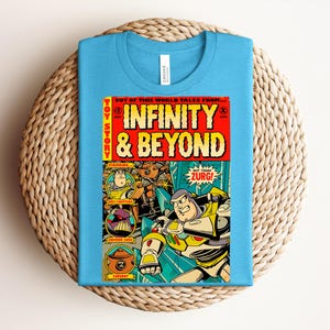 Puede incluir: Una camiseta azul claro con un gr&aacute;fico de portada de c&oacute;mic titulado Infinity & Beyond. El dise&ntilde;o incluye los personajes Buzz Lightyear, Emperor Zurg y Zurgbot con el texto Out of this world tales from, Toy Story y Not today Zurg!