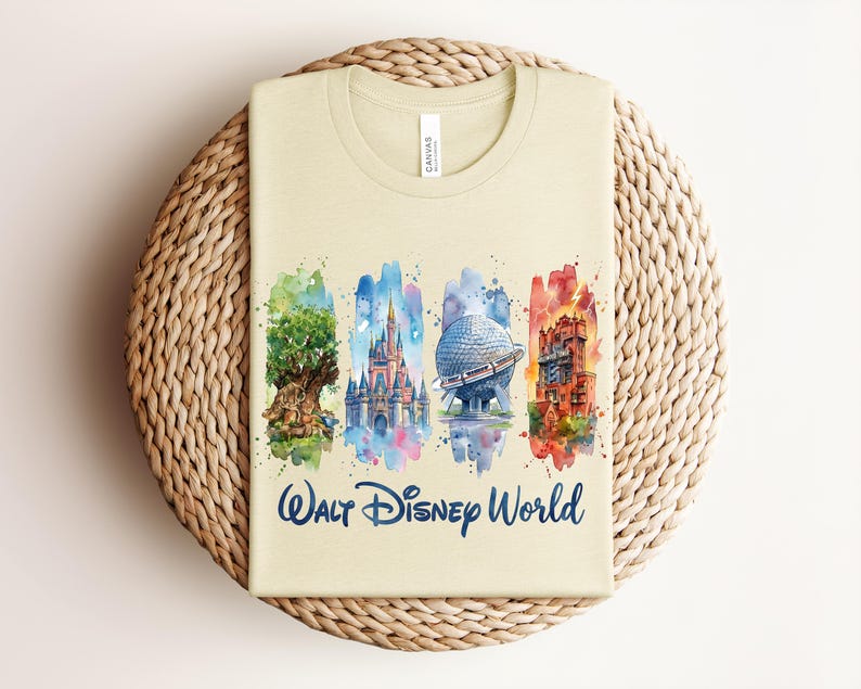 May include: Beige t-shirt featuring watercolor illustrations of iconic Walt Disney World landmarks: the Tree of Life, Cinderella Castle, Spaceship Earth, and the Tower of Terror. The words "Walt Disney World" are printed in a navy blue script below the images.