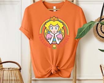 Camiseta "Feeling Peachy Princess Peach", camiseta gráfica arcoíris del Reino Champiñón de Super Mario, camiseta gamer plateada jaspeada, top de chica anime linda