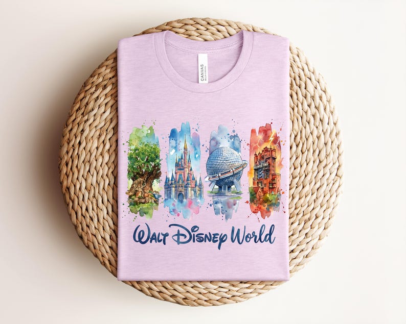 May include: A light purple t-shirt featuring watercolor illustrations of iconic Walt Disney World landmarks. The shirt includes images of the Tree of Life, Cinderella's Castle, Spaceship Earth, and the Tower of Terror, with "Walt Disney World" written below.