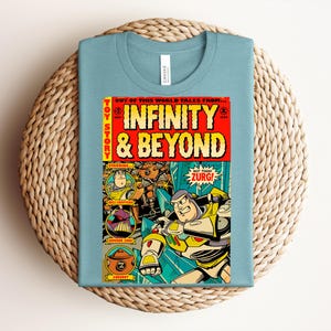 Puede incluir: Una camiseta azul claro con un estampado gr&aacute;fico de una portada de c&oacute;mic de estilo vintage titulada Infinity & Beyond. El dise&ntilde;o incluye ilustraciones de Buzz Lightyear, Emperor Zurg y Zurgbot, con el texto Not Today Zurg! en un globo.
