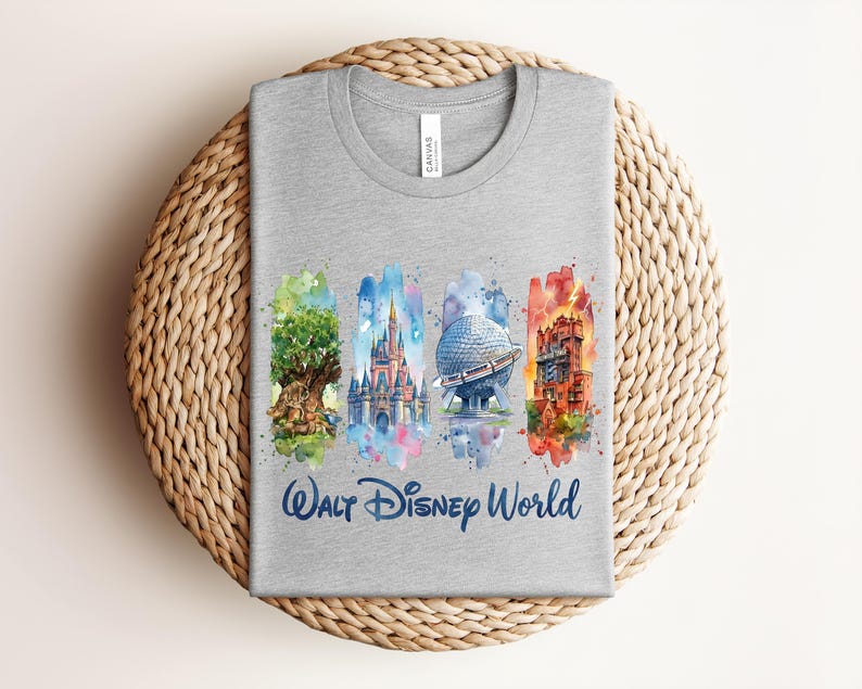 May include: A gray t-shirt featuring watercolor illustrations of iconic Walt Disney World landmarks. The design includes the Tree of Life, Cinderella Castle, Spaceship Earth, and Tower of Terror, with "Walt Disney World" written below.