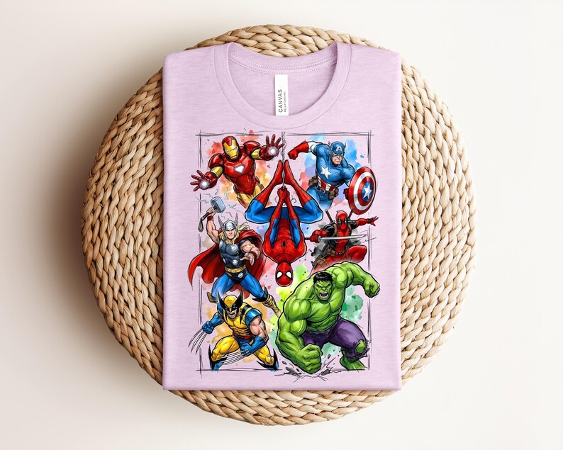 May include: A lilac t-shirt displaying a vibrant graphic of Marvel superheroes such as Iron Man, Captain America, Spider-Man, Thor, Wolverine, Hulk, and Deadpool. The design is framed with a watercolour effect.