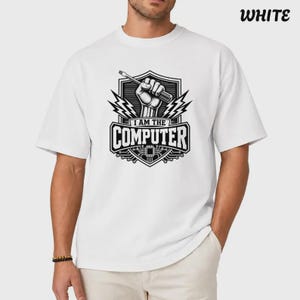 May include: A white short-sleeved t-shirt featuring a black graphic print on the chest. The design depicts a hand holding a screwdriver inside a shield emblem with lightning bolts and the text I AM THE COMPUTER above a circuit board pattern.