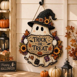 May include: A hanging wall sign shaped like a ghost wearing a black witch hat with sunflowers. The ghost holds a sign that reads Trick or Treat with bats and a pumpkin illustration. The base features a patchwork pattern and autumn leaves.
