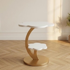 May include: A two-tiered side table with a cloud-shaped top and bottom shelf. The shelves are white, supported by a gold-colored, curved stem and a circular base. The table is designed for decorative use.