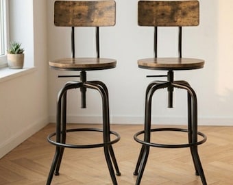 Könnte beinhalten: Zwei Barhocker im Industriestil mit dunklen Metallrahmen und Sitzflächen und Rückenlehnen aus Holz. Die Sitze sind rund und verstellbar, mit einer Fußstütze. Die Holzelemente haben eine Used-Optik. Die Hocker stehen auf einem Holzboden.