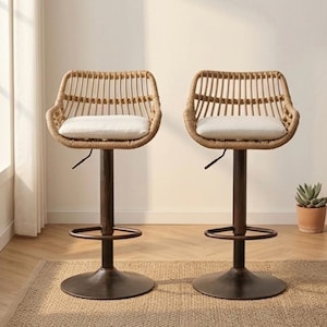 May include: Two woven rattan bar stools with a light brown finish. Each stool has a curved back, a white cushion, and a dark brown metal base with a footrest. The stools are on a woven rug.