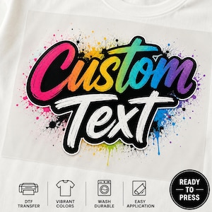 May include: A DTF transfer sheet featuring the words Custom Text in a bold, brush-stroke font with a vibrant rainbow gradient. The design is set against a black background with colorful paint splatters and includes icons for application.