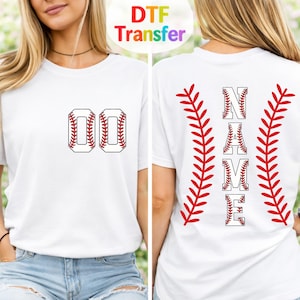 May include: A white short-sleeve t-shirt featuring a front chest graphic of the number 00 in a baseball stitch pattern. The back displays the word NAME vertically, flanked by two large red baseball stitch graphics on either side of the text.