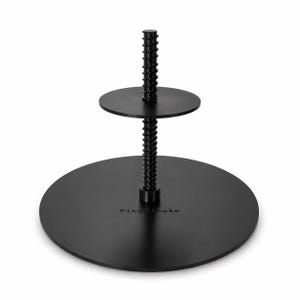 May include: Black two-tiered cake stand with a central threaded rod. The stand has two circular platforms, one large and one small, connected by a threaded rod. The base has the text "ping cake".