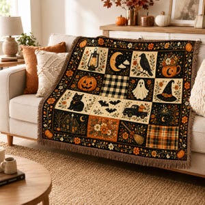 May include: A woven throw blanket featuring a grid of Halloween-themed illustrations including a jack-o'-lantern, a black cat, a ghost, a crow, a witch hat, a lantern, a truck with pumpkins, a broom, and floral patterns with a fringed edge.