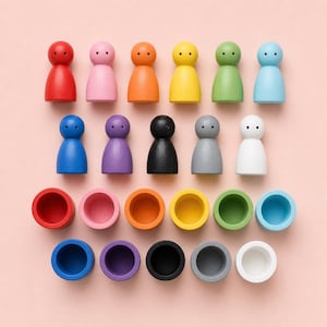 Puede incluir: Un conjunto de muñecos de madera de colores y tazas a juego sobre una superficie rosa. Los muñecos son de varios colores, incluyendo rojo, rosa, naranja, amarillo, verde, azul, morado, negro, gris y blanco. Las tazas son de colores correspondientes.