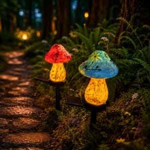 Könnte beinhalten: Zwei solarbetriebene Gartenleuchten in Pilzform mit farbigen Glaskappen. Eine hat eine rote Kappe, die andere blau. Beide haben gelb leuchtende Körper und sind auf schwarzen Pfählen entlang eines Waldweges angebracht.
