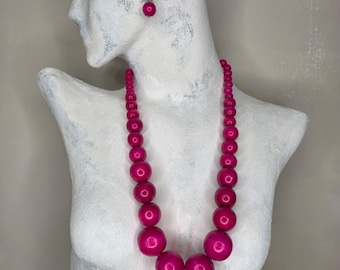 Collar de cuentas fucsia y pendientes a juego.