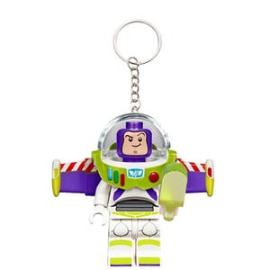 Puede incluir: Un llavero del personaje Buzz Lightyear que presenta una minifigura de pl&aacute;stico con un casco de c&uacute;pula transparente, alas de color morado y verde lima con rayas rojas y blancas, y un traje blanco. La figura tiene un accesorio verde y una anilla.