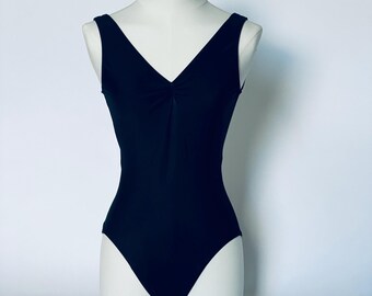 A classic low back black sleeveless  pinch front v-neck  womans  and girls leotard or swimsuit.