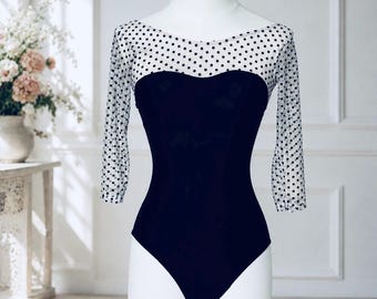 A  sleeved black leotard with white and black polka dot mesh bodice