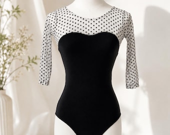 A  sleeved black leotard with white and black polka dot mesh bodice  in  a size XS